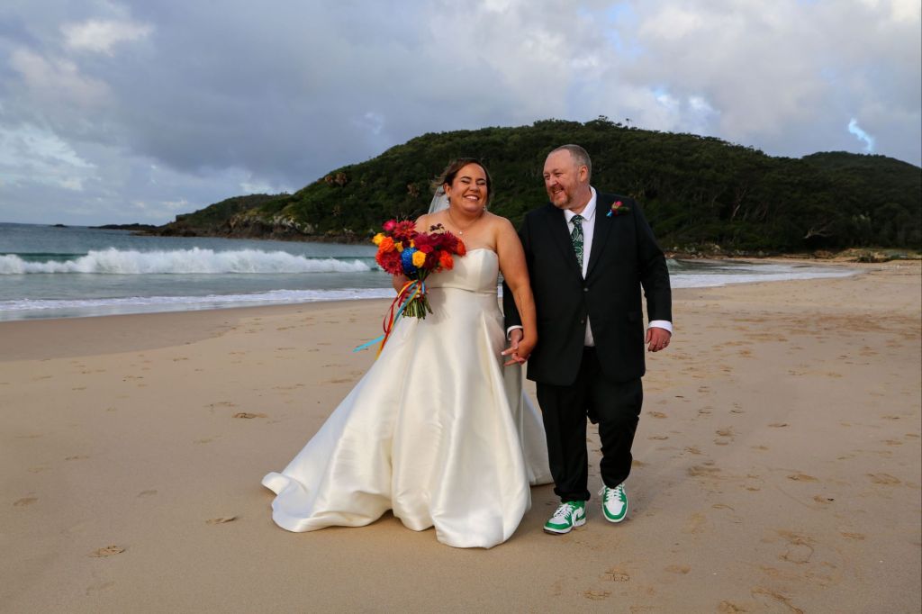 beach wedding, bride and groom walking, mountain, love, Forster NSW wedding bright flowers wedding photography 